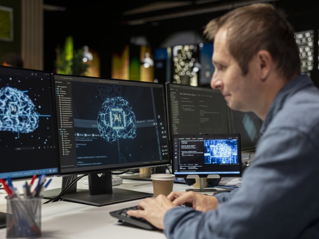 AI developer reviewing neural network model on multiple monitors