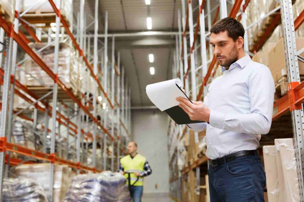Warehouse manager performing hardware acceptance with inventory checklist