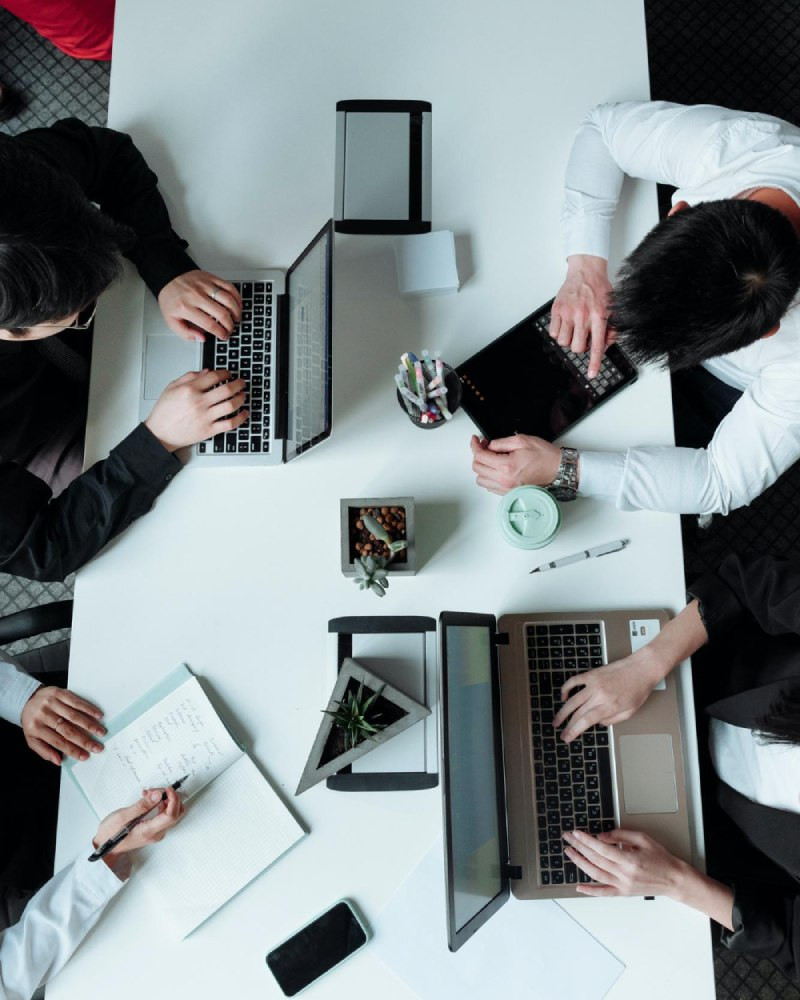 IT consulting team strategy meeting with laptops — overhead view