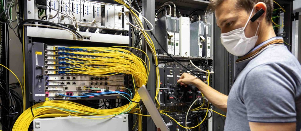 Technician installing fiber optic cables in server rack