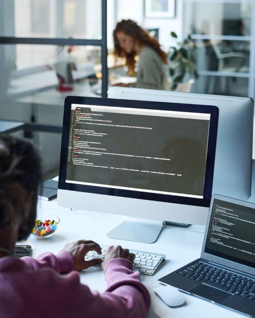 Software developer coding at a monitor