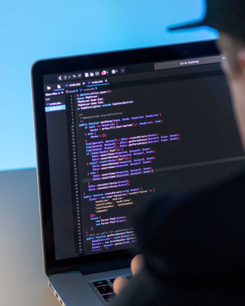 Software developer writing code on a laptop
