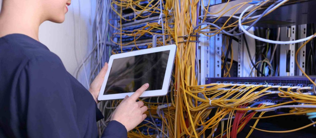 System integration — checking network cable rack connections with tablet